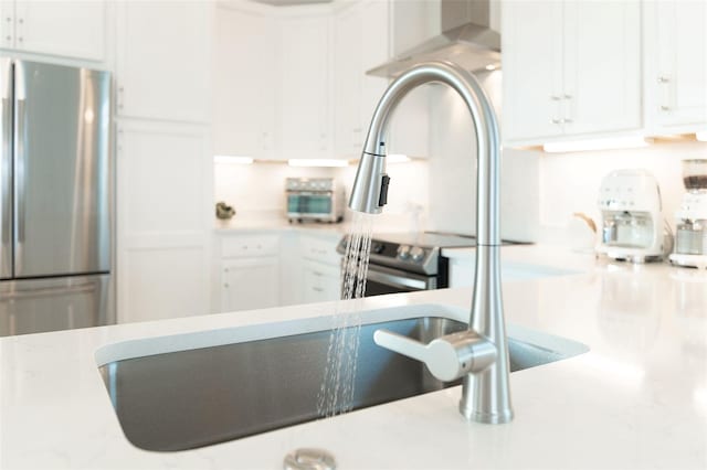 room details featuring stainless steel refrigerator and white cabinetry