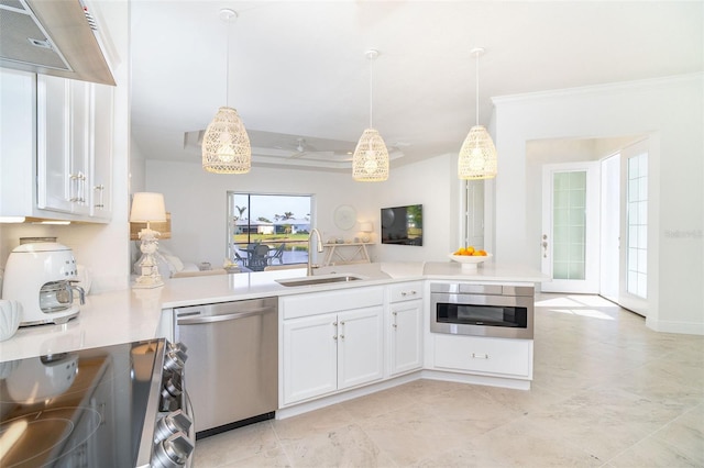 kitchen with appliances with stainless steel finishes, decorative light fixtures, sink, white cabinets, and kitchen peninsula