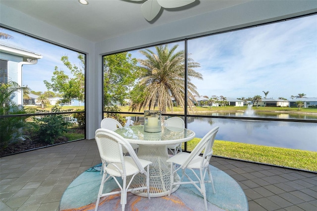 sunroom / solarium with a water view, a healthy amount of sunlight, and ceiling fan