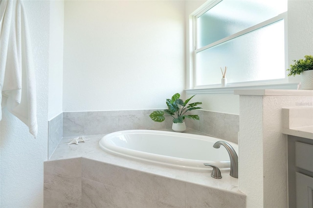 bathroom with vanity and a relaxing tiled tub