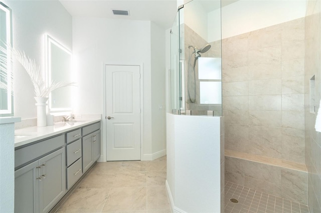 bathroom with vanity and a tile shower