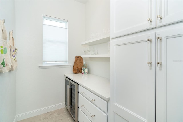 kitchen with white cabinetry, beverage cooler, and light tile patterned flooring