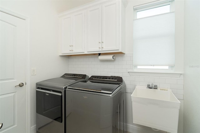 washroom featuring sink, washer and clothes dryer, and cabinets