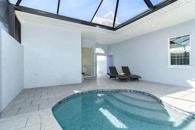 view of pool with a patio area and glass enclosure