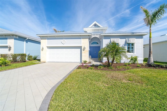 8768 Conch Ave, Placida, FL 33946 - view of front facade with a front yard, a garage, driveway, and metal roof