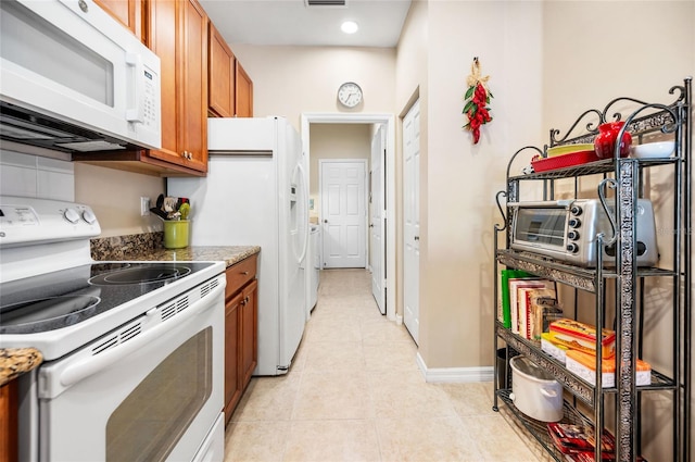 kitchen with light stone counters, white appliances, and light tile patterned floors