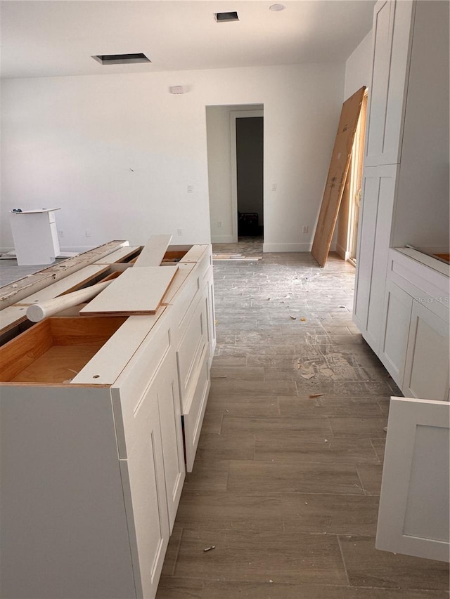 interior space with white cabinetry and wood finished floors