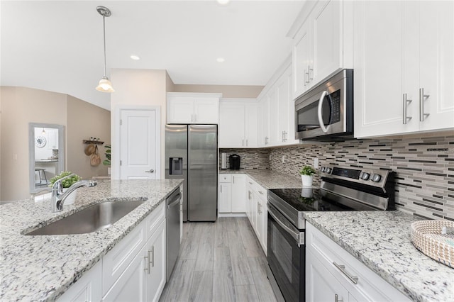 kitchen with stainless steel appliances, decorative light fixtures, sink, and white cabinets