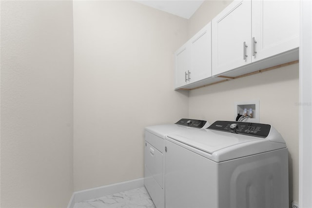 clothes washing area featuring cabinets and washing machine and dryer