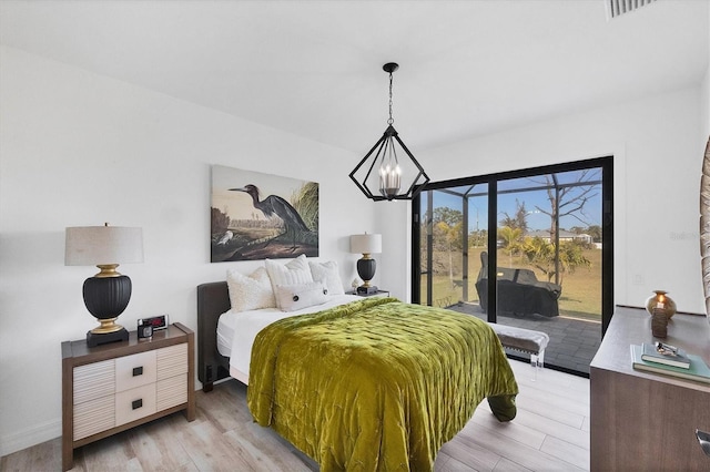 bedroom featuring access to outside, an inviting chandelier, and light hardwood / wood-style flooring