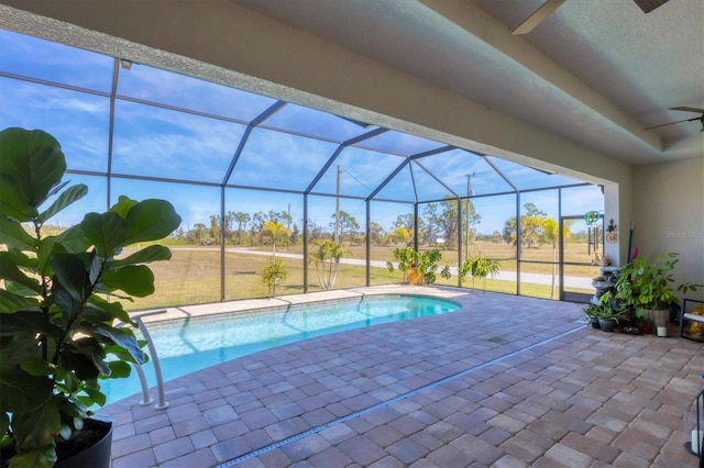 view of pool featuring a patio, ceiling fan, and glass enclosure