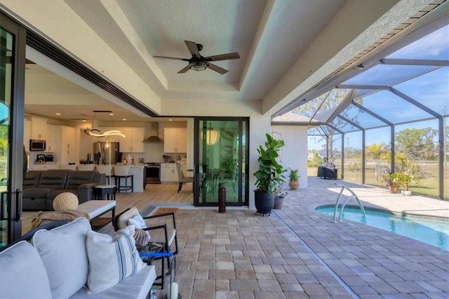 view of swimming pool with a lanai, an outdoor kitchen, outdoor lounge area, and a patio area