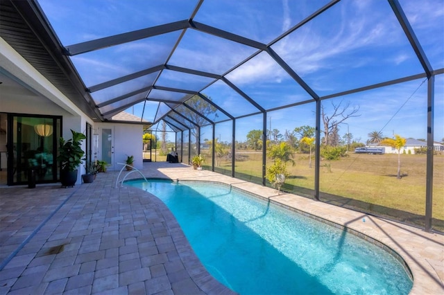 view of pool featuring a lawn, glass enclosure, and a patio area