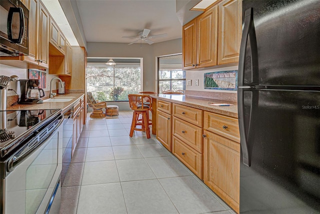 kitchen with ceiling fan, sink, light tile patterned floors, and black appliances