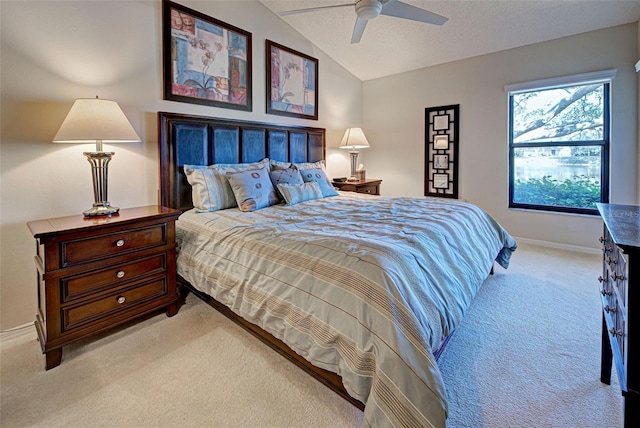 bedroom featuring vaulted ceiling, light colored carpet, a textured ceiling, and ceiling fan