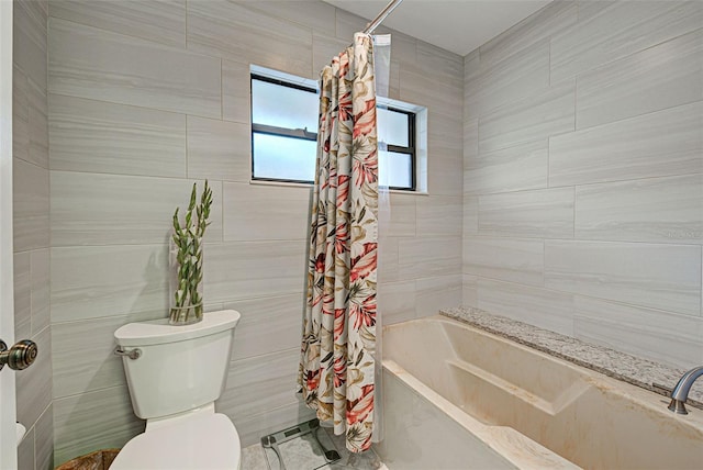 bathroom featuring tile walls, shower / tub combo, and toilet