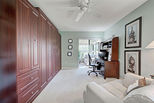 carpeted home office featuring ceiling fan and a textured ceiling