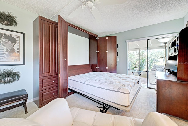 carpeted bedroom with ceiling fan, access to outside, and a textured ceiling