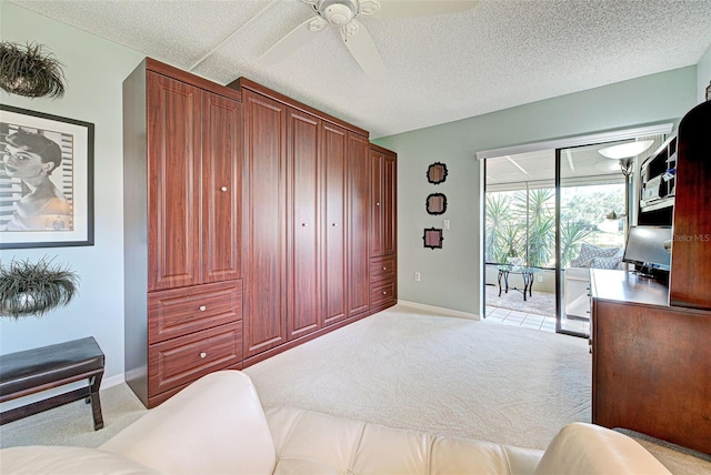 carpeted office space with ceiling fan and a textured ceiling