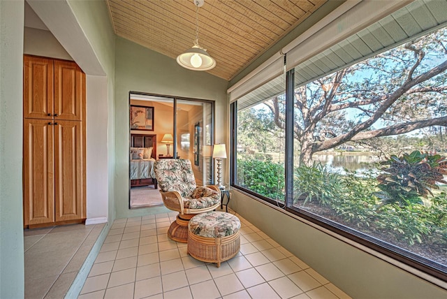 sunroom featuring a water view, lofted ceiling, and wooden ceiling