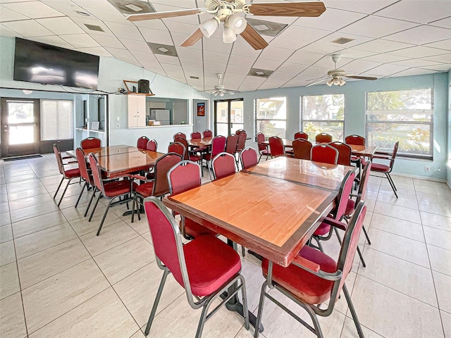 tiled dining area with ceiling fan and a drop ceiling