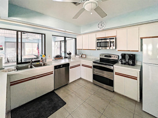 kitchen featuring sink, white cabinetry, light tile patterned floors, appliances with stainless steel finishes, and ceiling fan