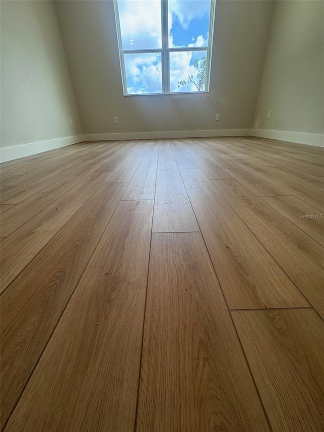 unfurnished room with light wood-style flooring and baseboards