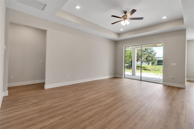2814 Vogler Ln, North Port, FL 34286 - empty room featuring a tray ceiling, light wood finished floors, a ceiling fan, and recessed lighting