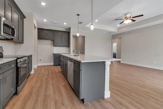 2814 Vogler Ln, North Port, FL 34286 - kitchen with stainless steel appliances, light wood-style flooring, light countertops, an island with sink, and recessed lighting