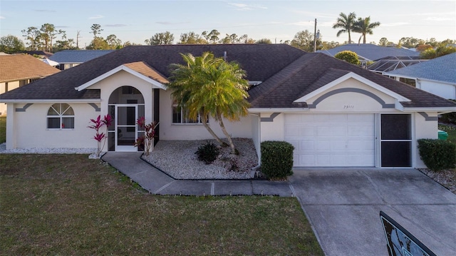 ranch-style house with a garage and a lawn