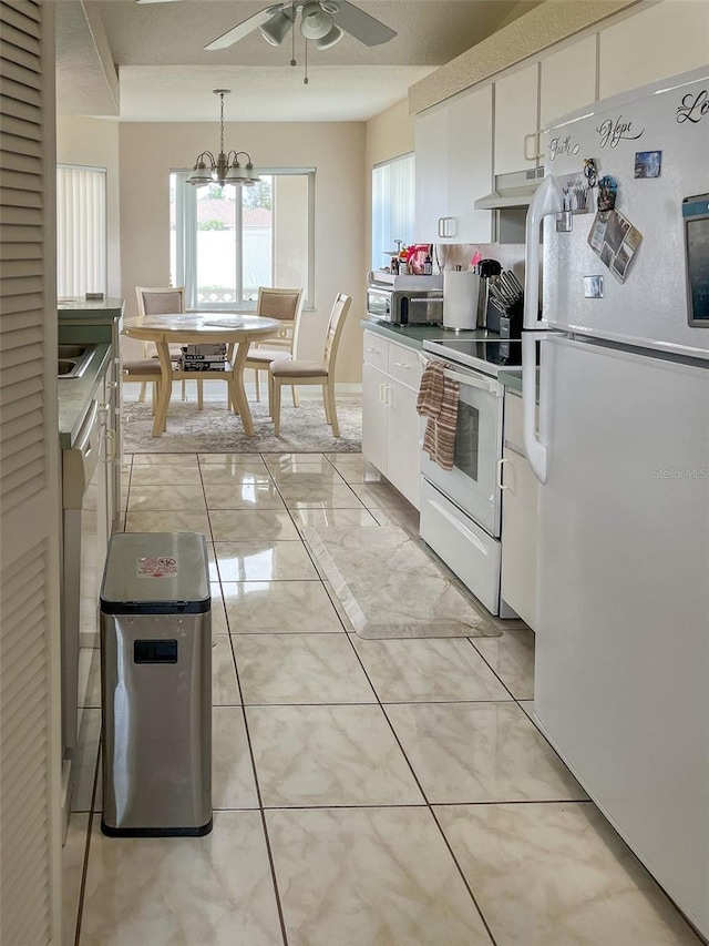 kitchen featuring white cabinetry, ceiling fan with notable chandelier, pendant lighting, and white appliances