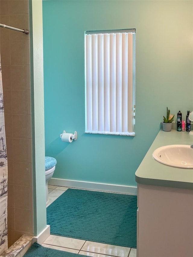 bathroom with a shower with curtain, vanity, tile patterned floors, and toilet