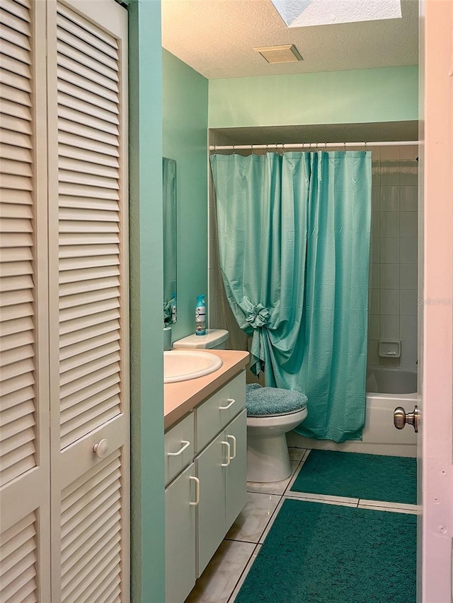 full bathroom with tile patterned flooring, vanity, a textured ceiling, toilet, and shower / bath combo with shower curtain