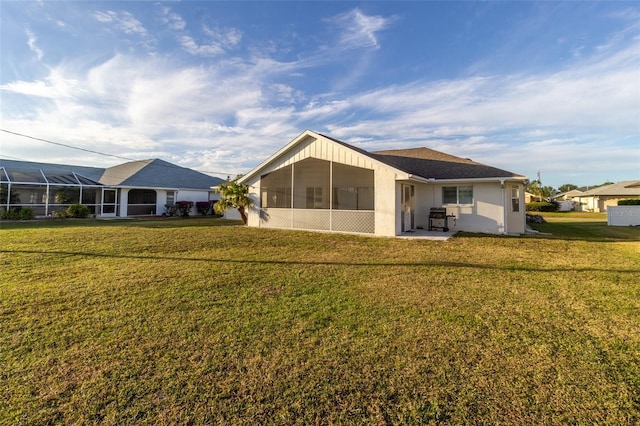 rear view of property featuring a yard and a lanai