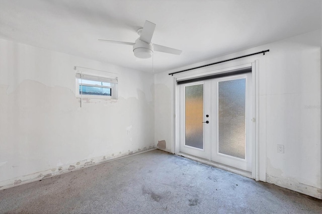 carpeted spare room with ceiling fan and french doors