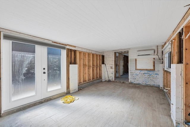 unfurnished room featuring a wall mounted air conditioner and light wood-type flooring