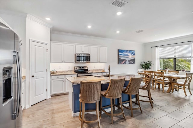 24269 Spartina Dr, Venice, FL 34293 - kitchen featuring sink, a kitchen island with sink, stainless steel appliances, light stone countertops, and white cabinets