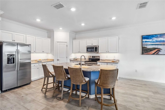 24269 Spartina Dr, Venice, FL 34293 - kitchen with a kitchen island with sink, sink, white cabinets, and appliances with stainless steel finishes
