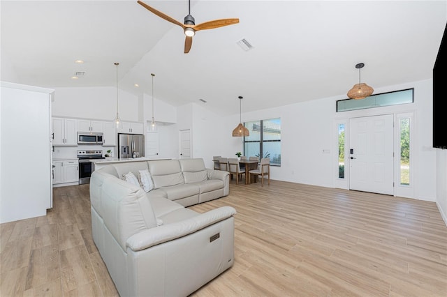 living area featuring visible vents, light wood-style flooring, high vaulted ceiling, and a ceiling fan