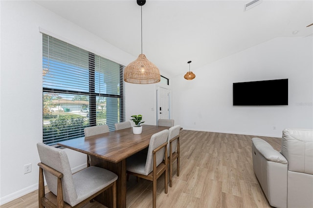 dining area featuring lofted ceiling, baseboards, visible vents, and light wood finished floors