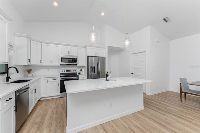 kitchen featuring visible vents, light wood-style flooring, white cabinets, stainless steel appliances, and a sink