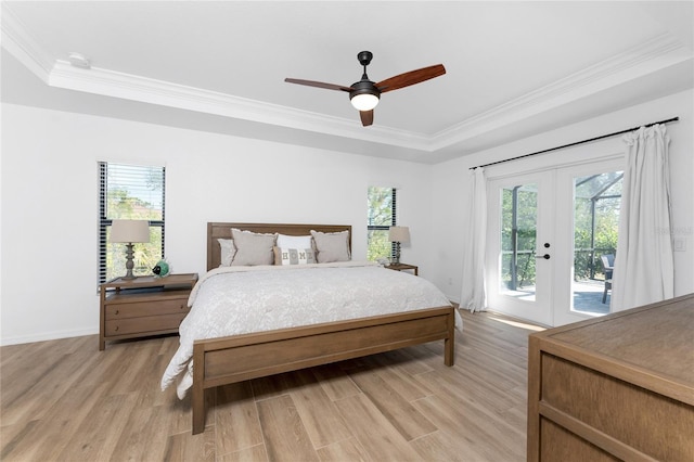 bedroom featuring a tray ceiling, access to outside, multiple windows, and french doors