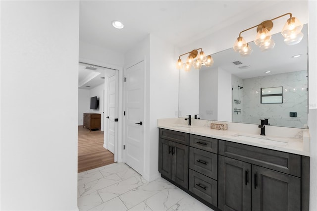 full bathroom with a marble finish shower, visible vents, marble finish floor, and a sink