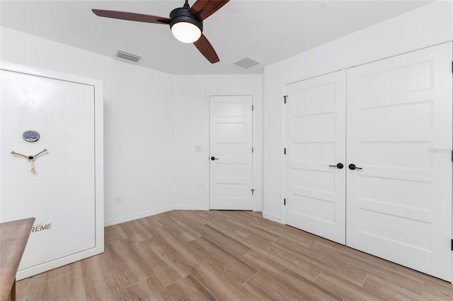 unfurnished bedroom with ceiling fan, light hardwood / wood-style floors, and a closet