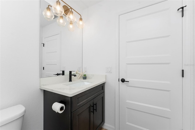 bathroom featuring vanity, toilet, and a chandelier