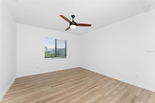 empty room with a ceiling fan, baseboards, and light wood finished floors