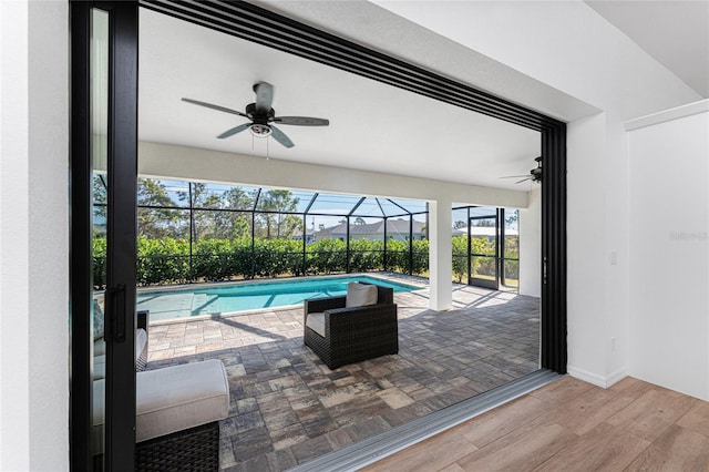 pool featuring a lanai, a patio area, and ceiling fan