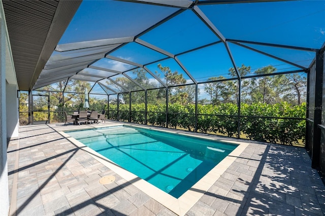 outdoor pool with glass enclosure and a patio