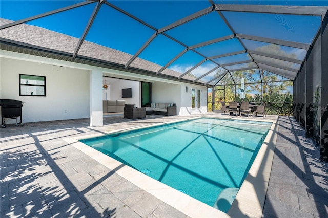 outdoor pool featuring glass enclosure, outdoor lounge area, and a patio area