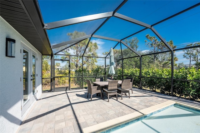 view of patio with an outdoor pool, glass enclosure, and outdoor dining area